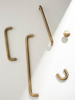 Set of brushed brass hooks on a white background