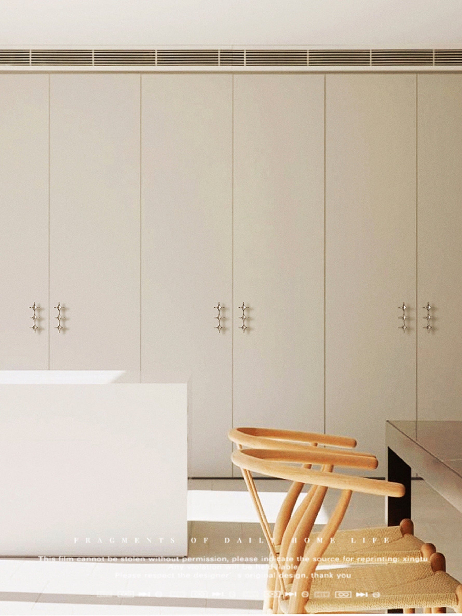 Polished chrome star cross pulls installed on beige wardrobe doors in modern living room