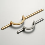 Satin gold and satin silver circle ring cabinet pulls side by side on grey background