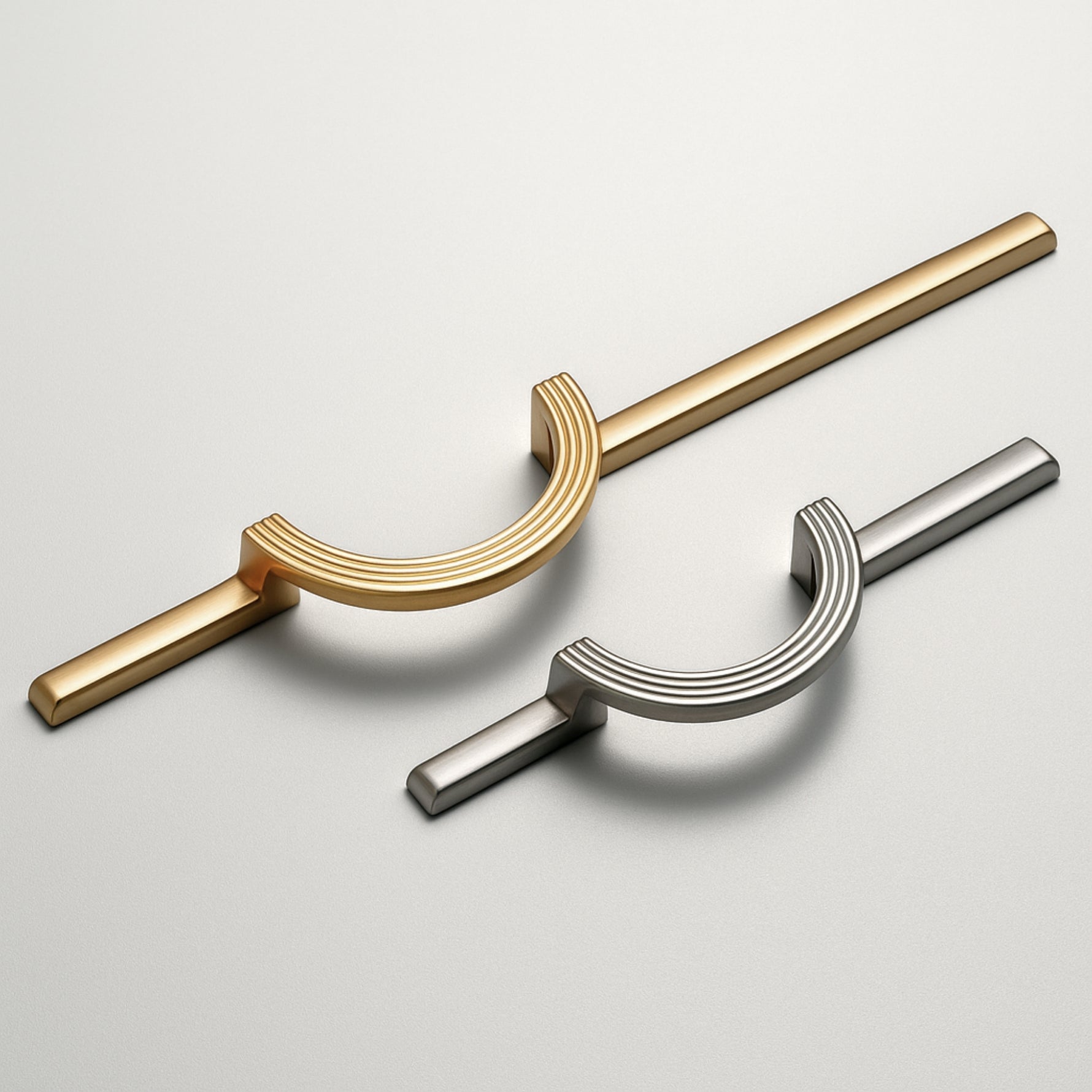 Satin gold and satin silver circle ring cabinet pulls side by side on grey background