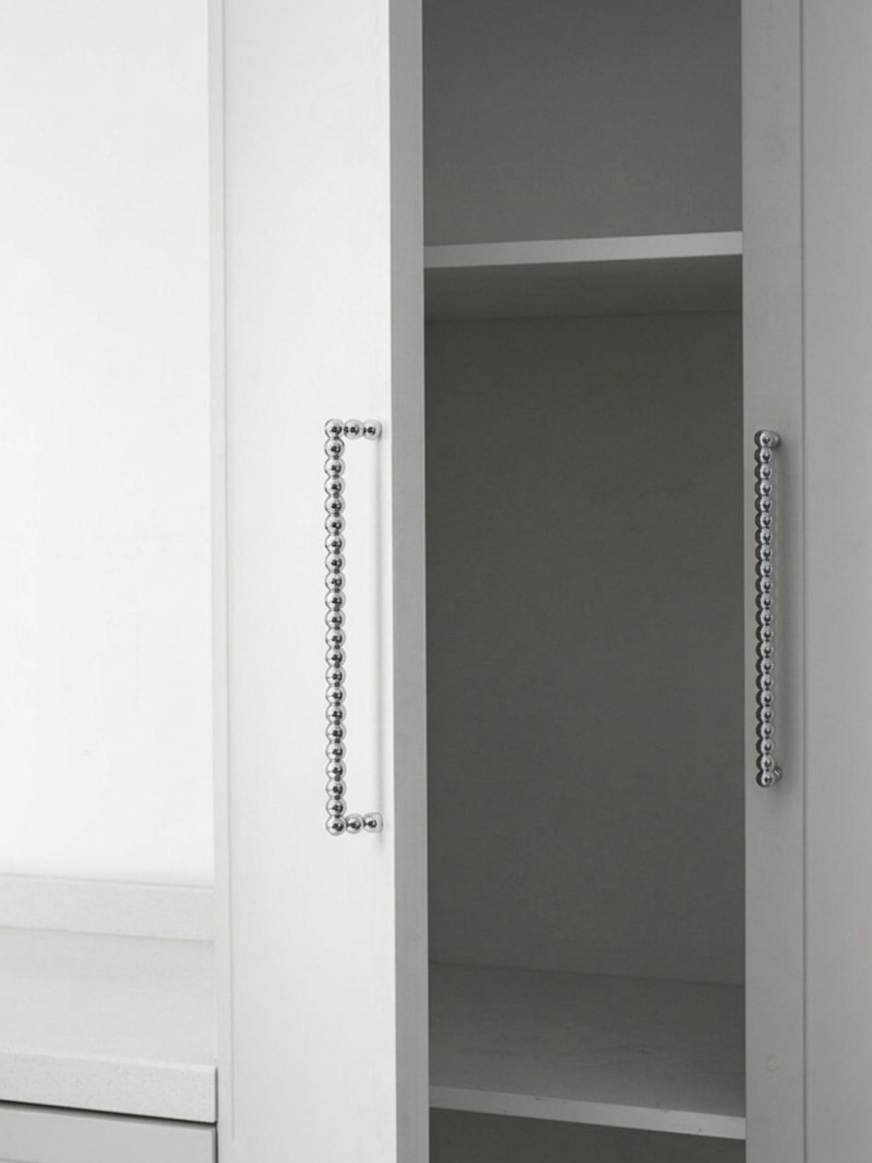 Two polished chrome beaded ball pulls on white wardrobe doors, vertical orientation