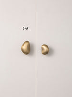 Mixed size C and A brushed brass pebble knobs styling