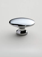 Polished chrome oval cabinet knob on white background — pedestal base side view