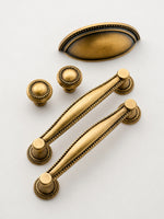 Antique brass beaded Victorian hardware — knobs cup pull and bar pulls flat lay