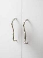 Chrome wave cabinet pull installed on white wardrobe doors
