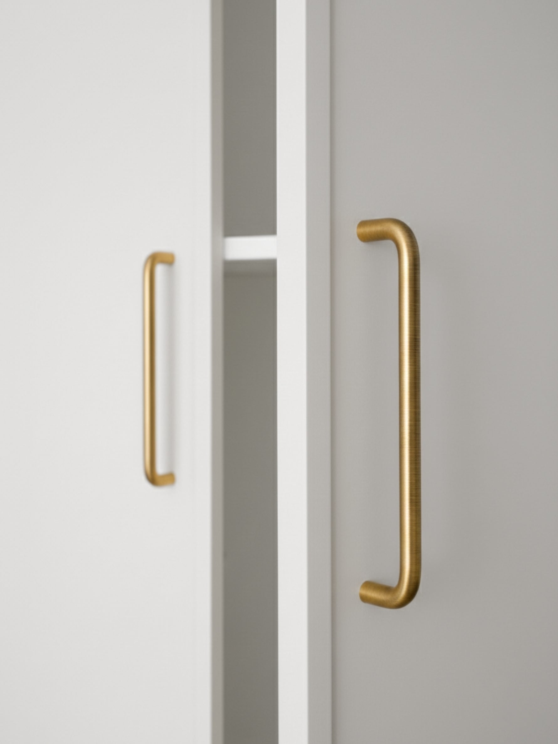 Close-up of a cabinet with brushed brass handles on a neutral background