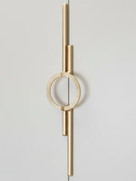 Satin gold circle ring cabinet pull mounted vertically on light grey wardrobe door
