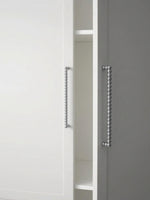 Close-up of polished chrome beaded ball pulls on white and grey cabinet doors