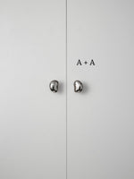 Polished chrome pebble knobs on white cabinet doors labeled size A plus A comparison