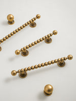 Set of antique brass cabinet handles on a beige background