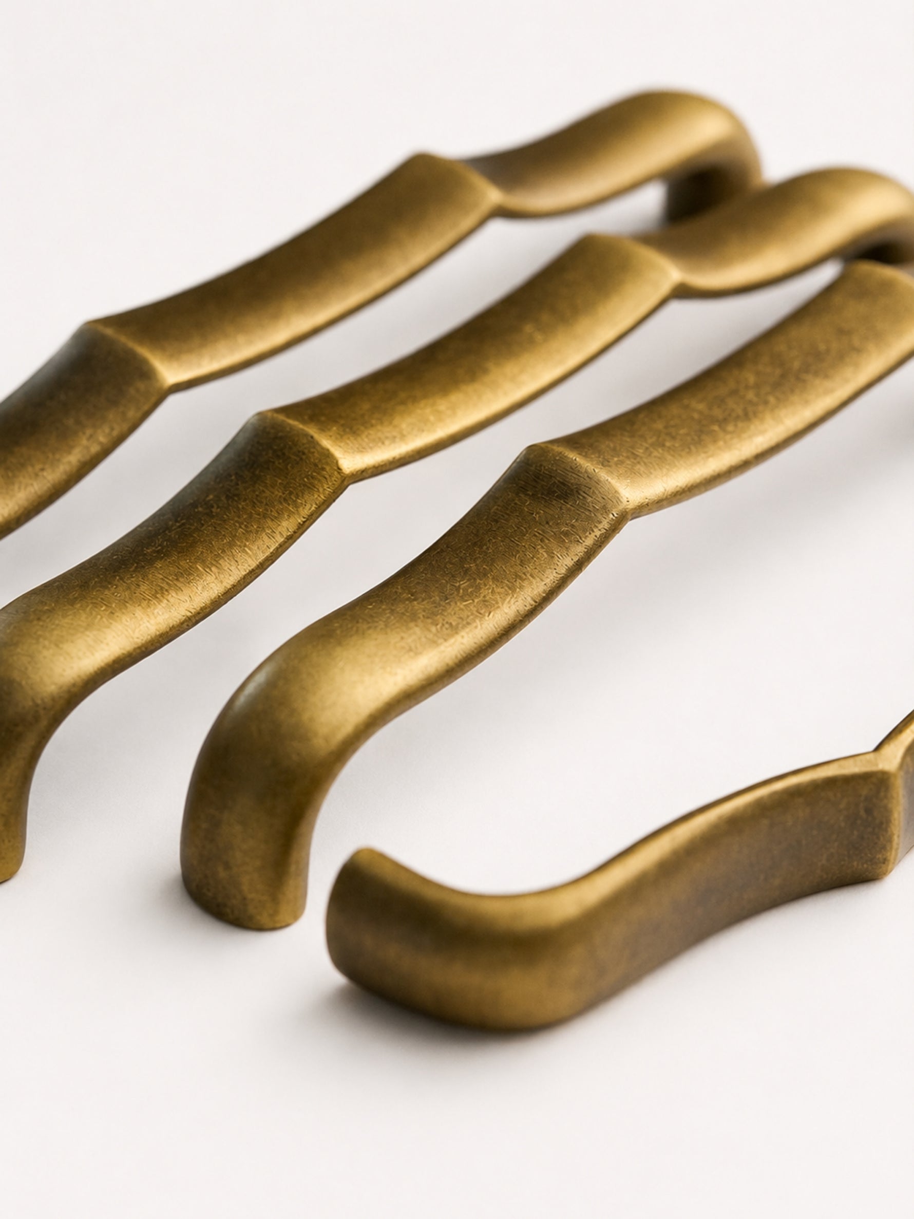 Close-up antique brass bamboo pull — wavy texture detail
