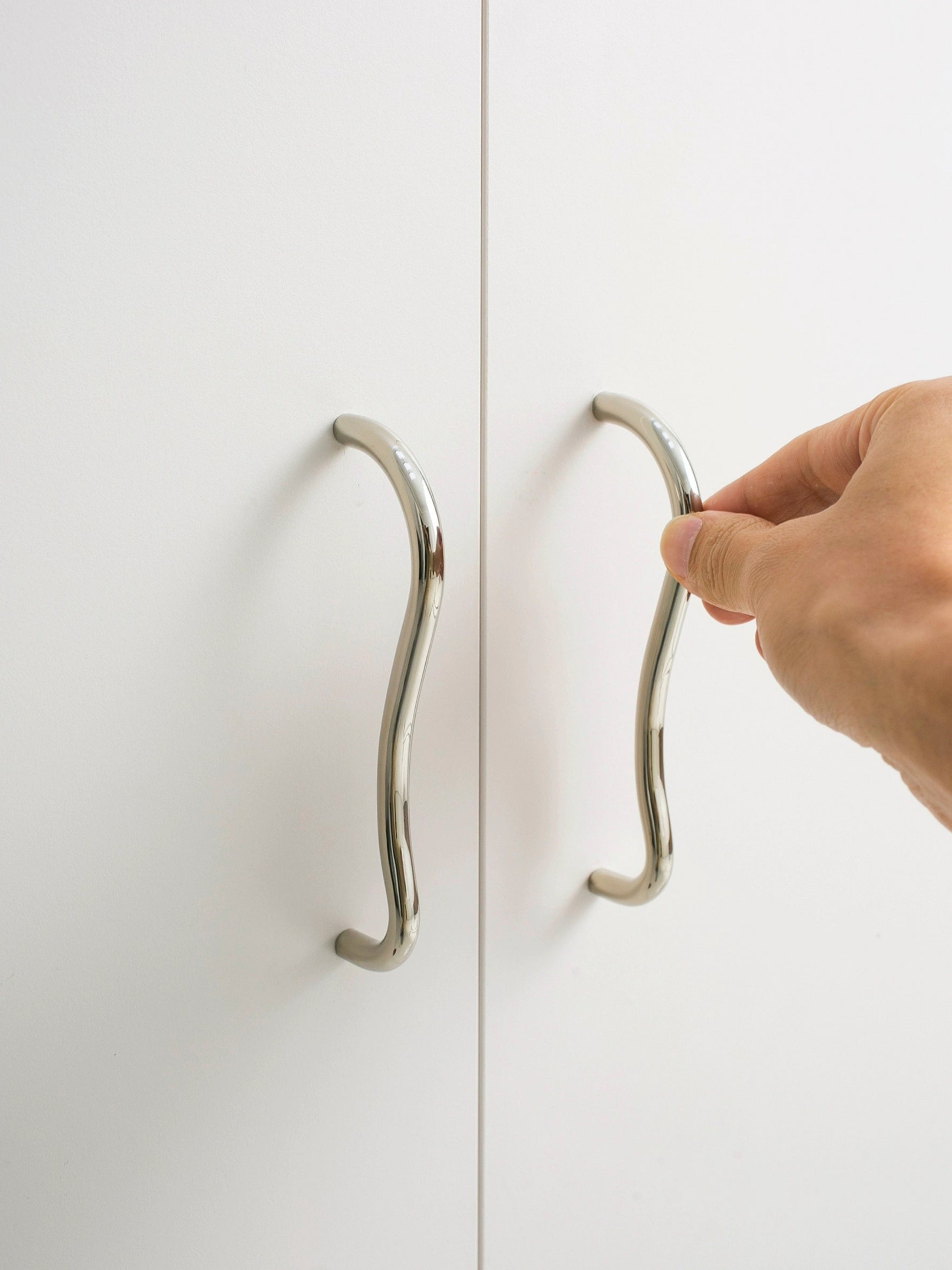 Hand opening wardrobe door using chrome wave pull