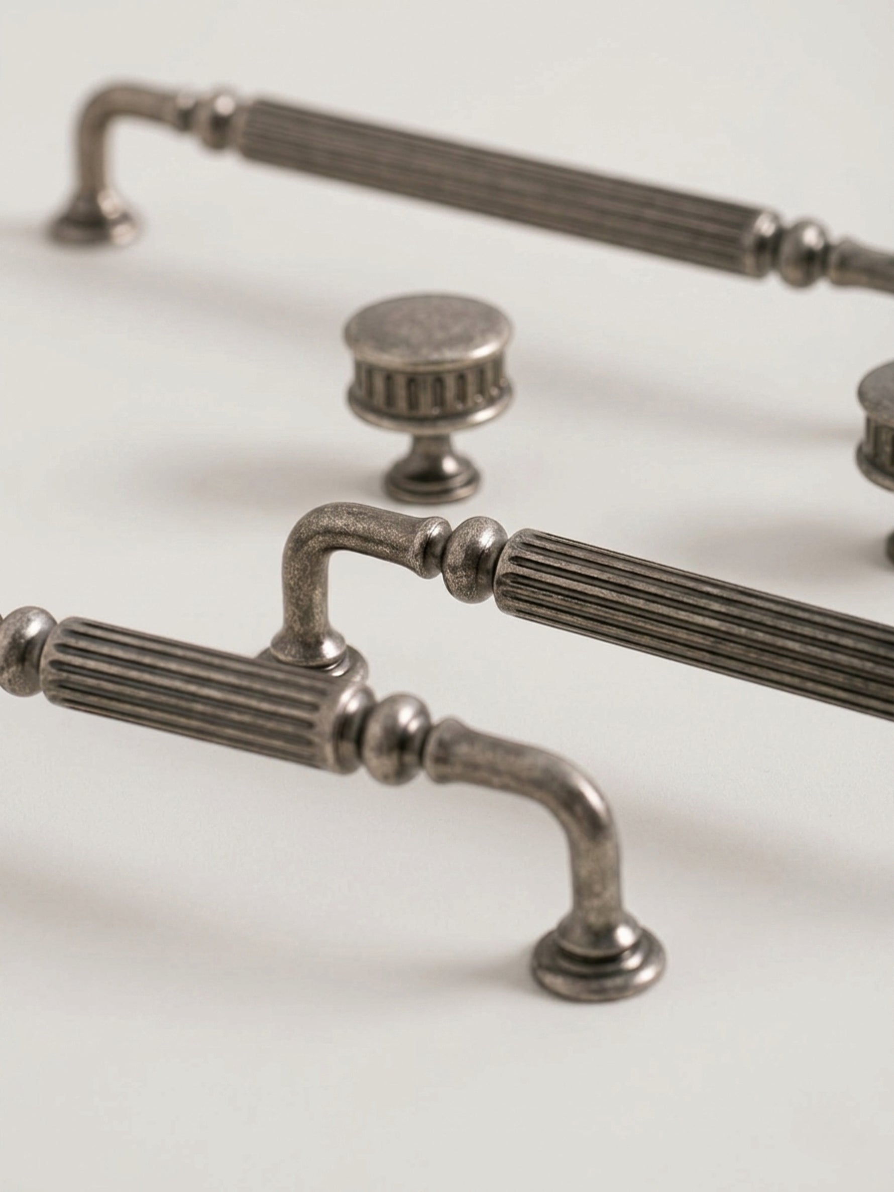 Antique silver reeded cabinet pulls and knob, close-up angled view
