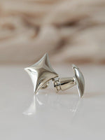Polished chrome star cabinet knob close-up on marble surface, side view