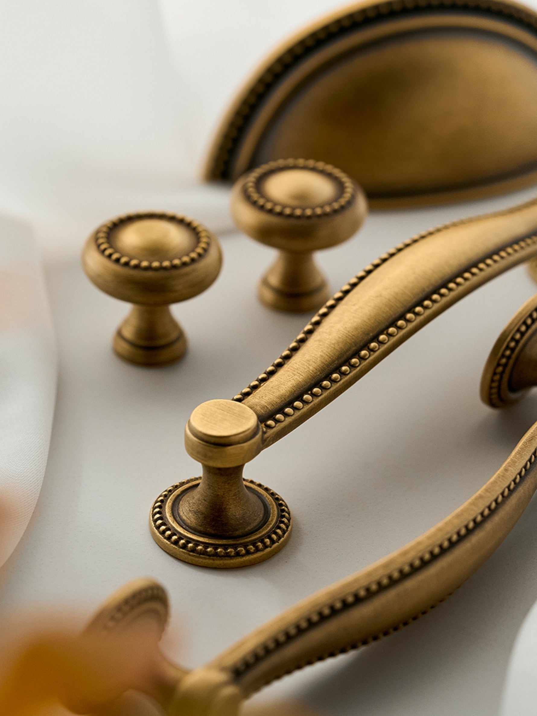 Antique brass beaded knobs cup pull and bar pull — styled arrangement