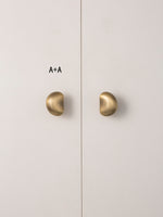 Size A brushed brass pebble knobs paired on wardrobe
