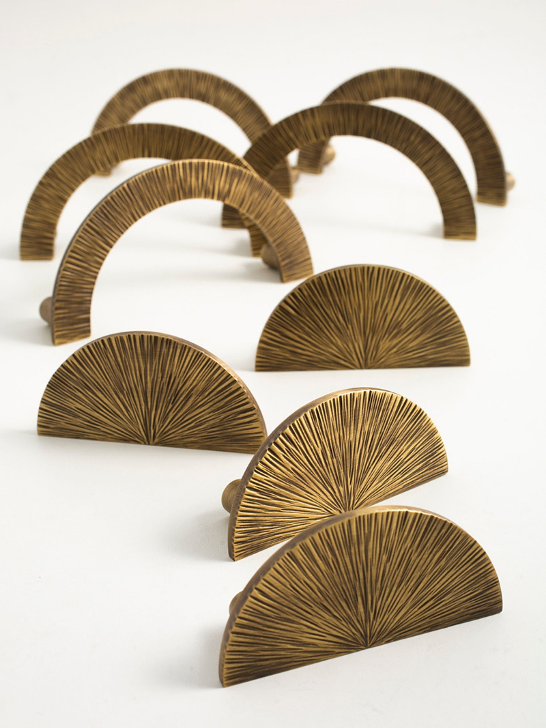 Multiple antique brass sunray arch pulls arranged in rows