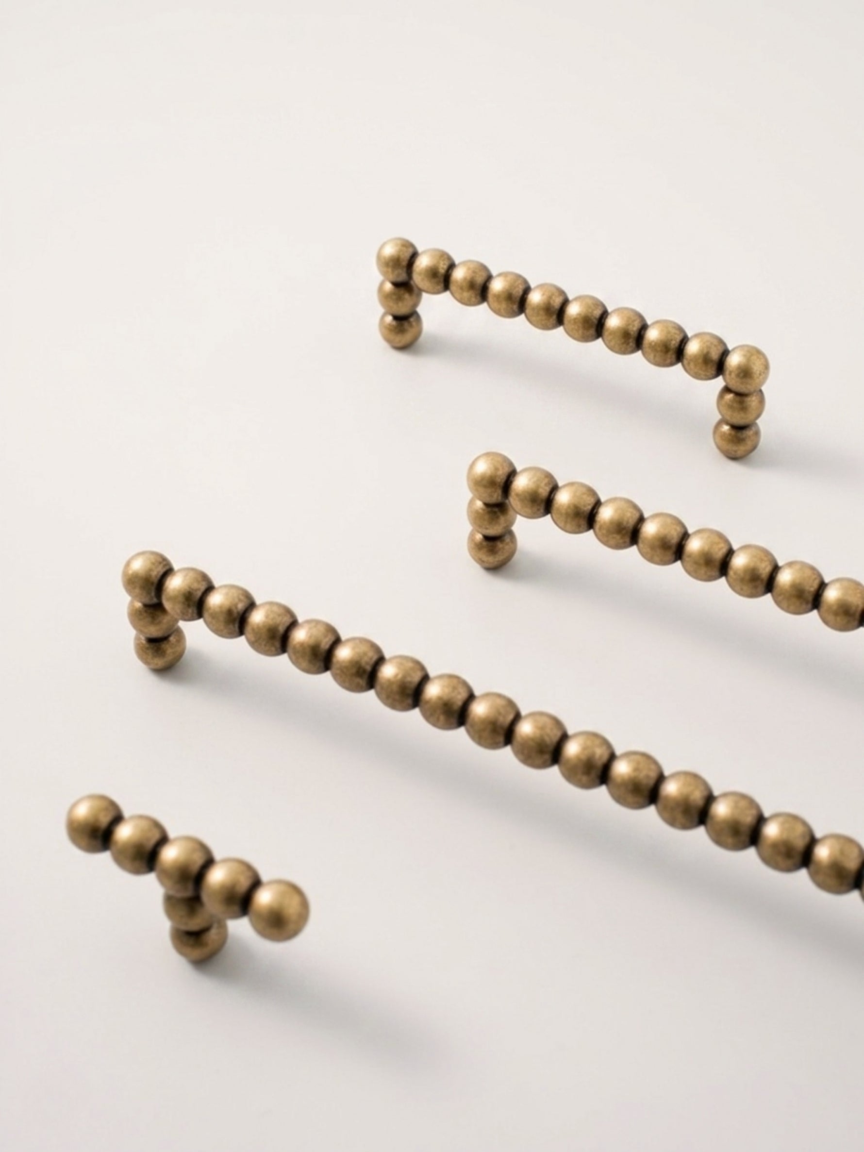 antique brass beaded drawer pulls on a light gray background