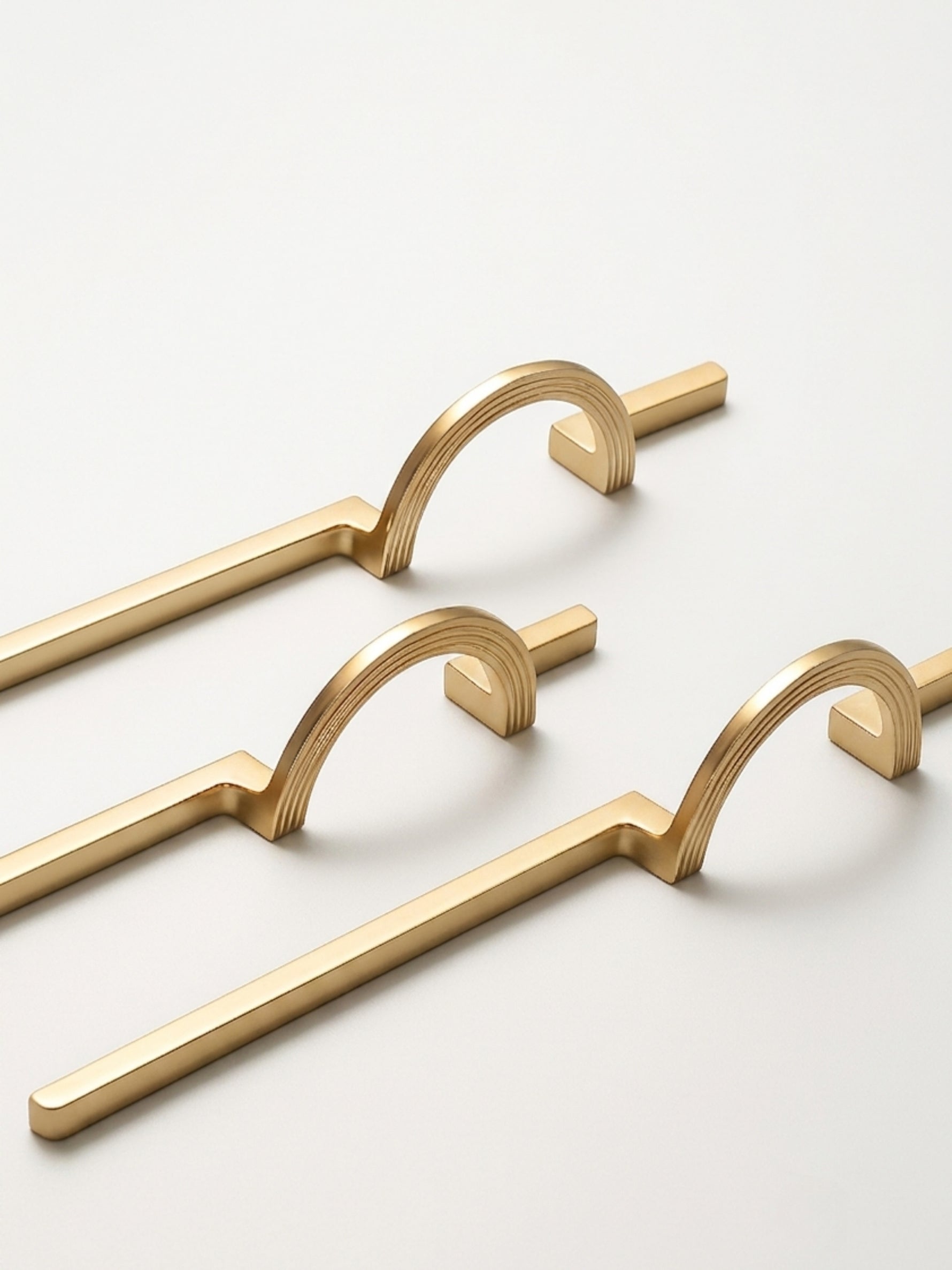 Three satin gold circle ring cabinet pulls on white background showing profile view