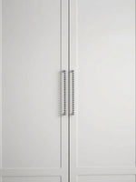 Two polished chrome beaded ball pulls on white shaker cabinet doors, front view