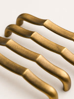 Antique brass bamboo pulls — end detail showing curved tips