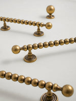 Close-up of decorative antique brass door handles on a beige background