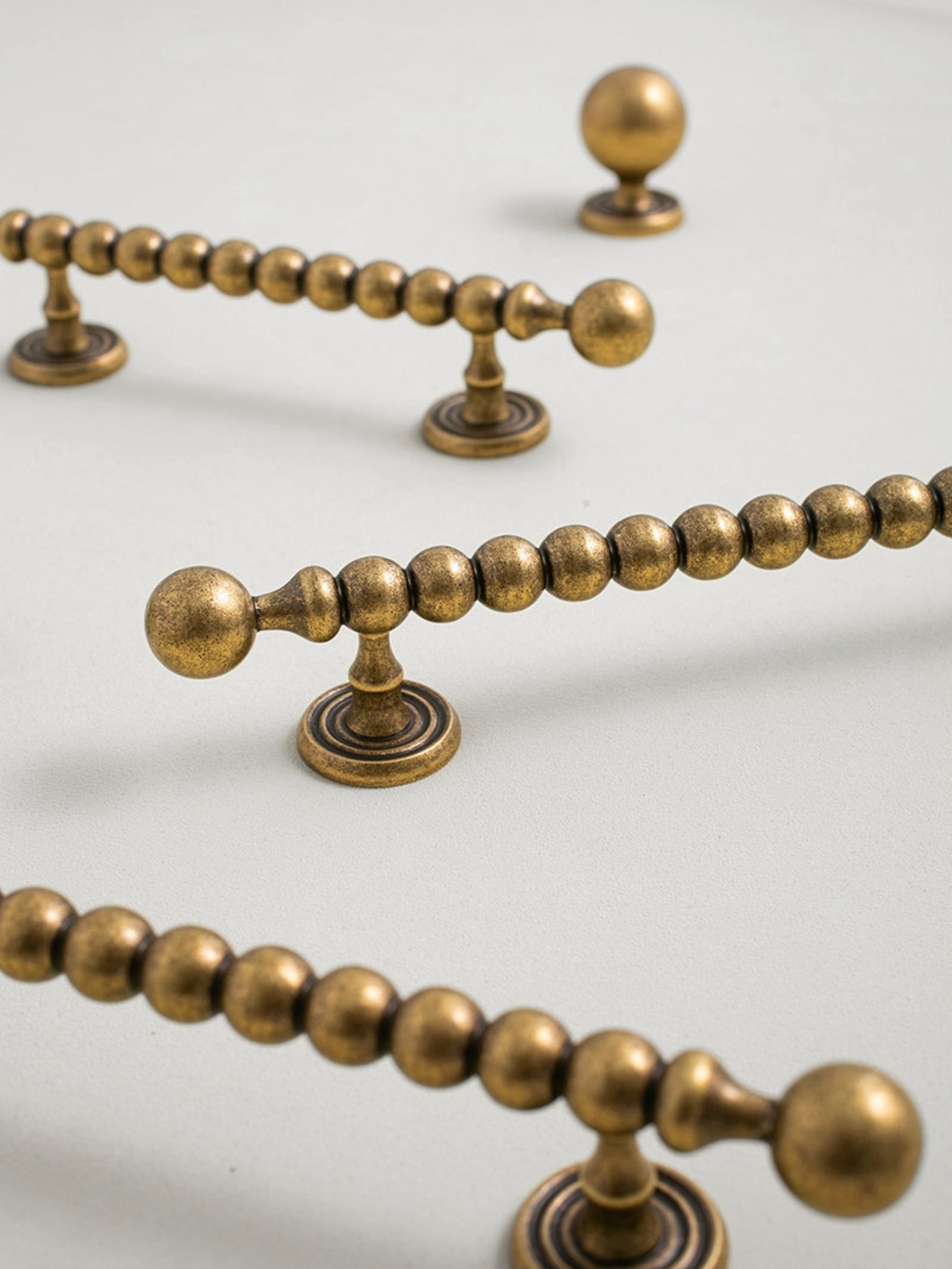 Close-up of decorative antique brass door handles on a beige background