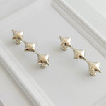 Pair of chrome star-shaped earrings on a white background