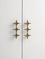 Antique Brass Star Cabinet Pull Installed on White Wardrobe Door