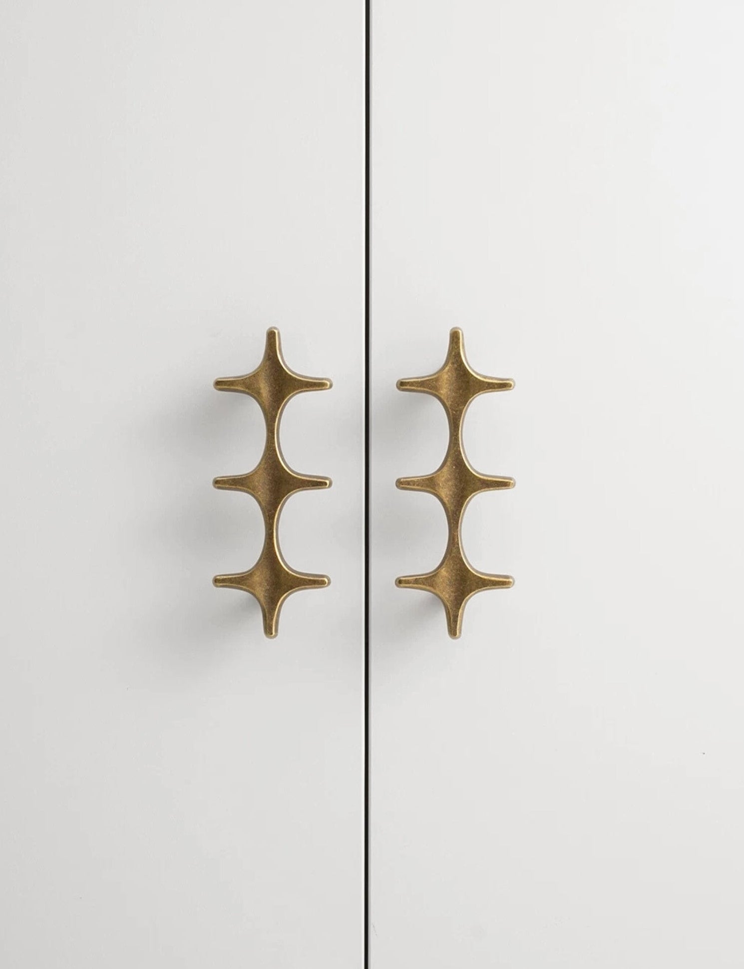 Antique Brass Star Cabinet Pull Installed on White Wardrobe Door