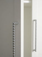 Close-up polished chrome beaded ball pull on grey and white cabinet edge showing bead detail