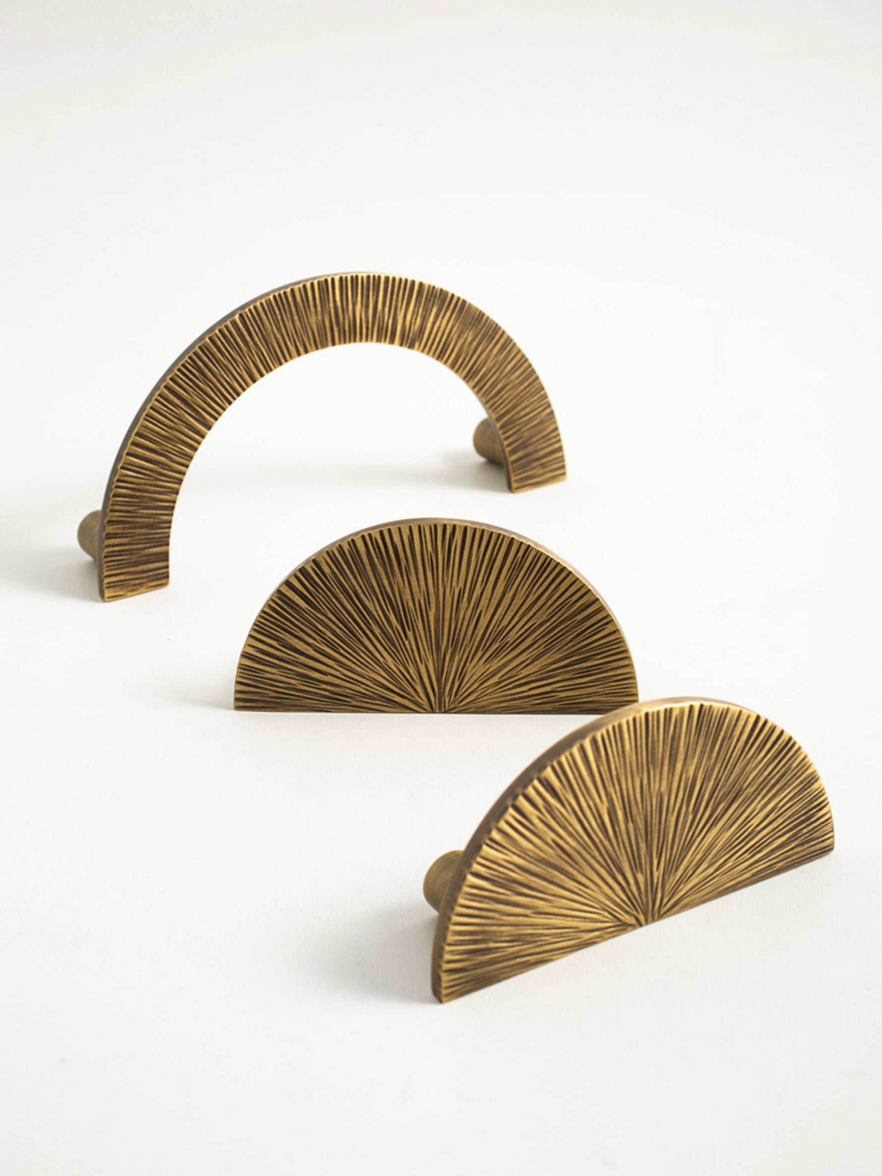 Three antique brass sunray pulls — arch and half-moon sizes
