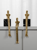 Three gold thinker figure pulls displayed on black marble base