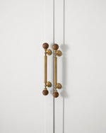Walnut ball pulls on white cabinet doors — front view