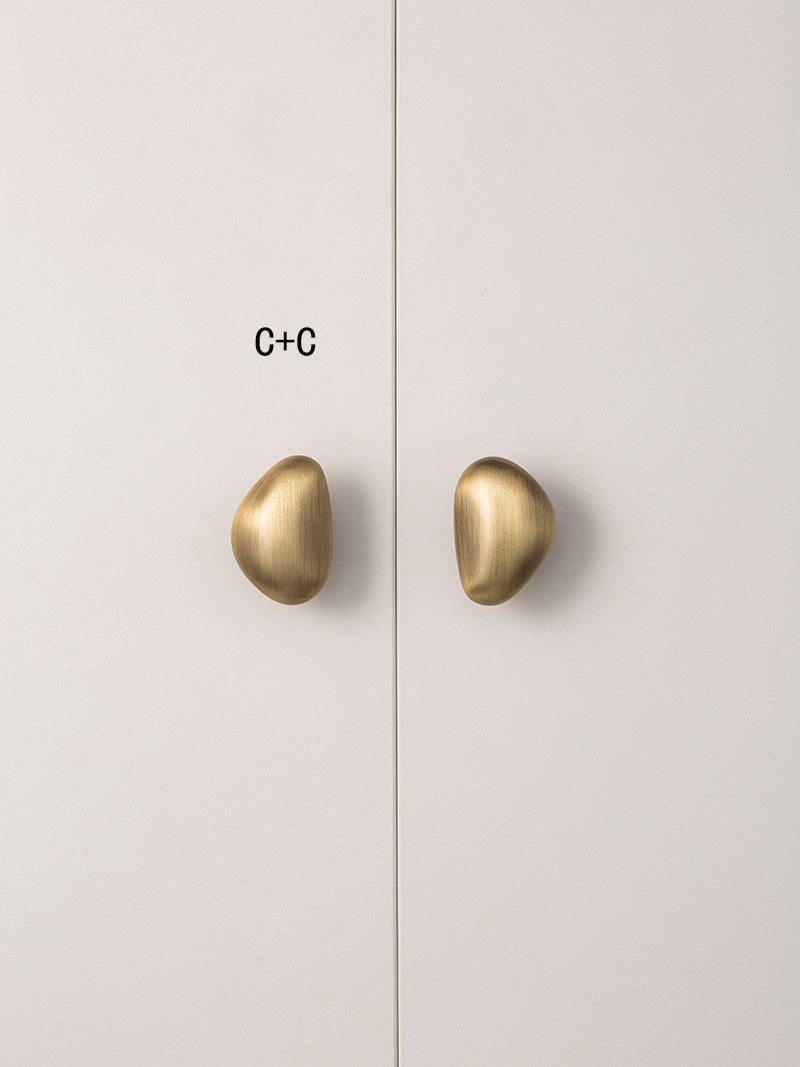 Size C brushed brass pebble knobs paired on wardrobe