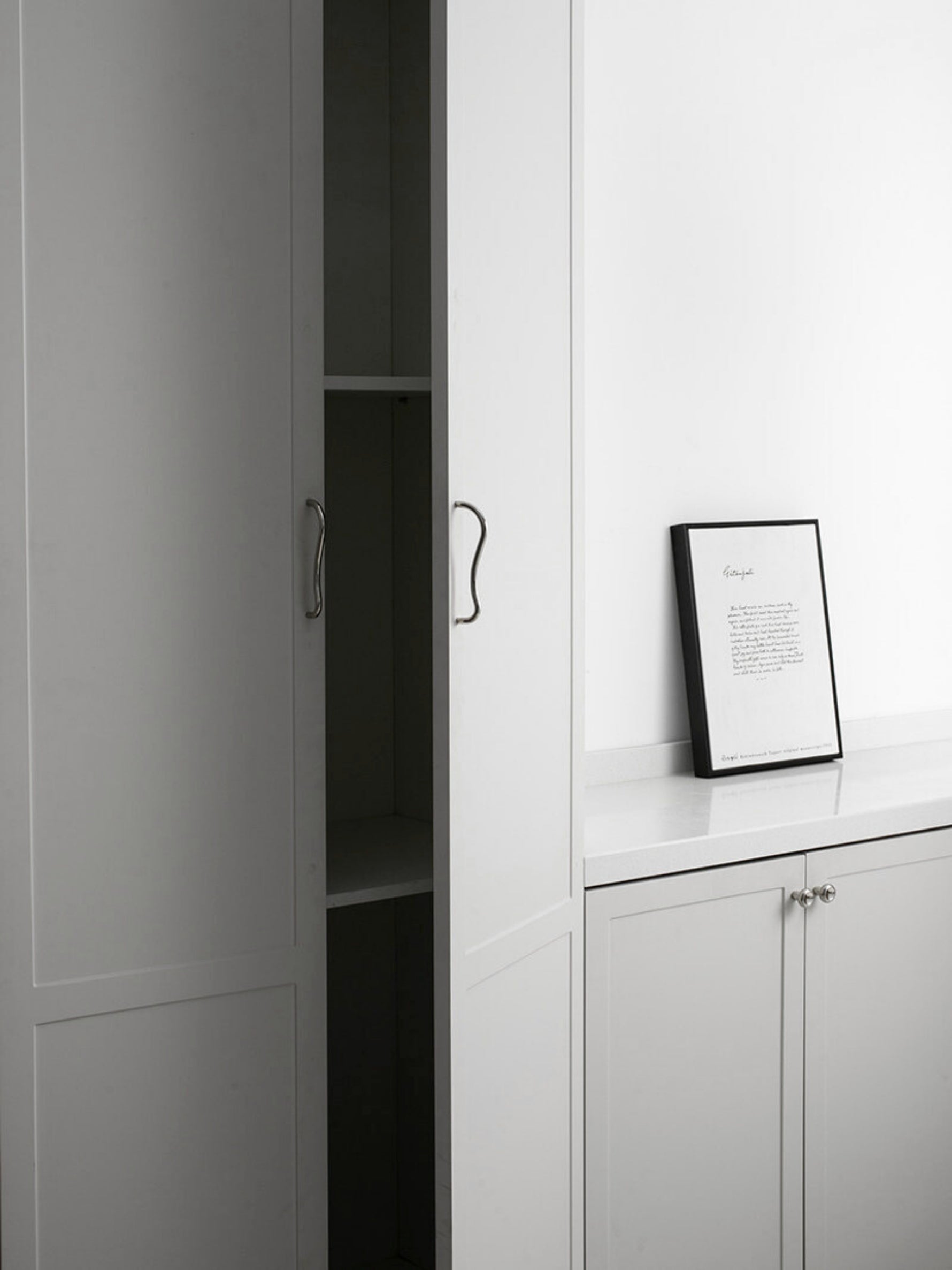 Chrome wave pulls on light grey wardrobe cabinetry