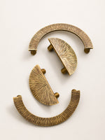 Antique brass sunray pulls — top view showing radiating texture