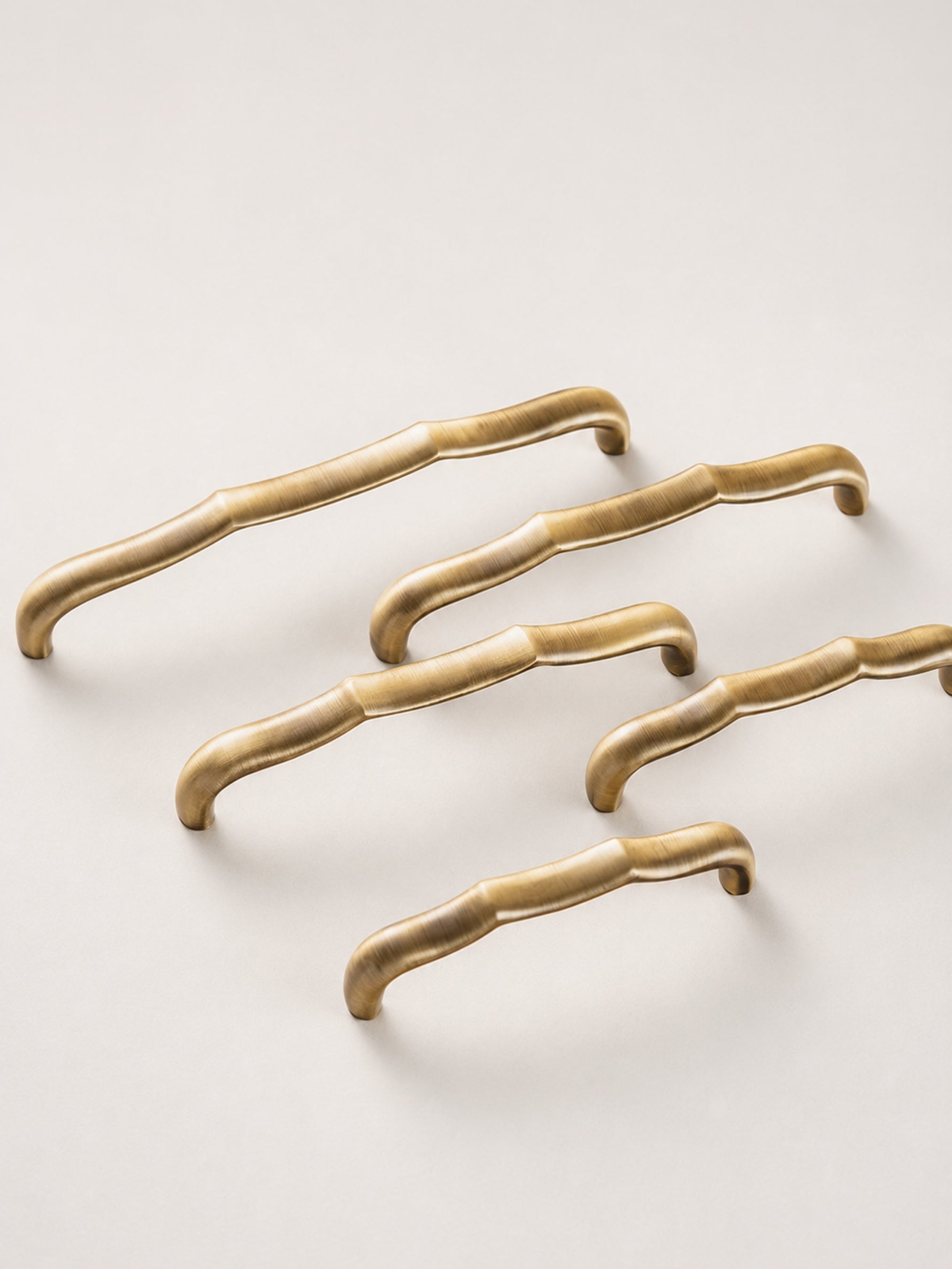 Antique brass bamboo pulls — diagonal arrangement flat lay