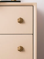 Single antique brass dice knob on blush pink drawer front