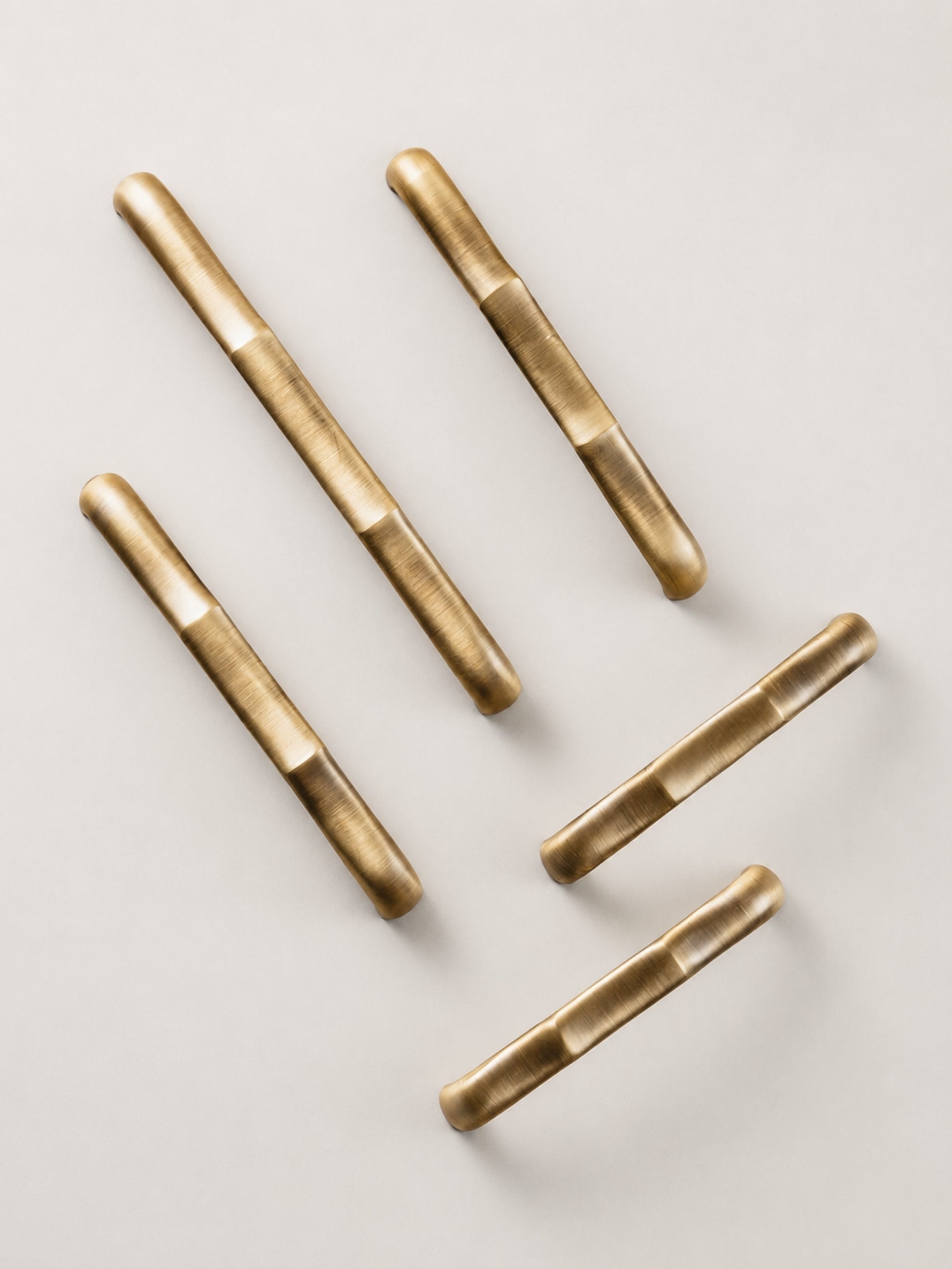Antique brass straight bamboo pulls — vertical flat lay