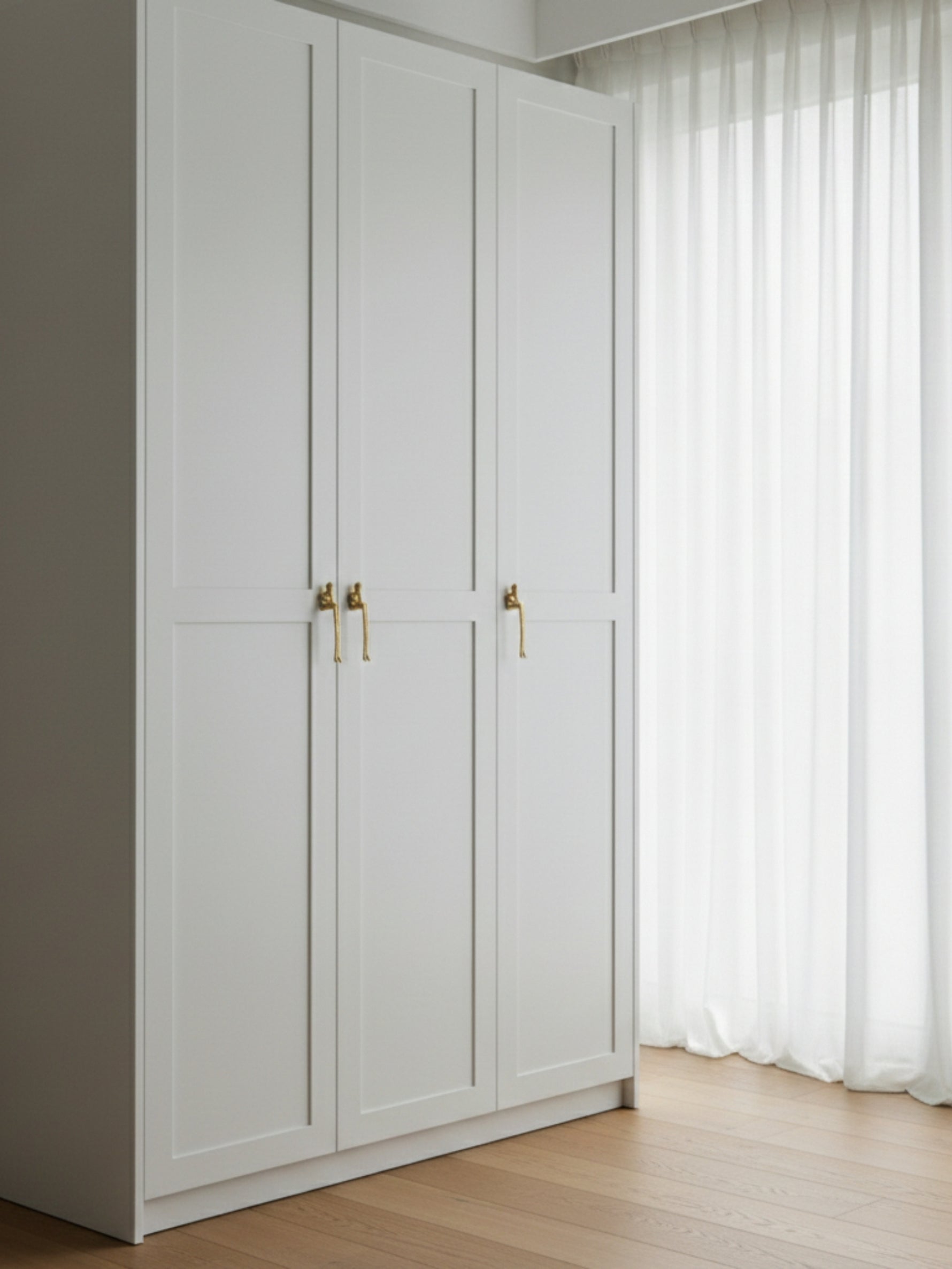 Gold thinker figure pulls on white built-in wardrobe