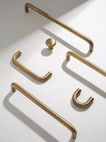 Set of brushed brass cabinet handles on a white background