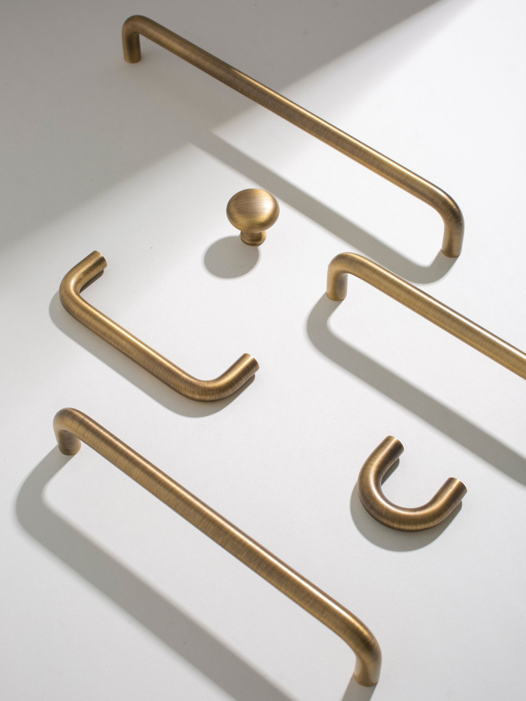 Set of brushed brass cabinet handles on a white background