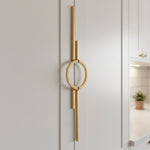 Satin gold circle ring pull on white shaker wardrobe door with kitchen in background