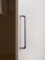 Single polished chrome bar pull on white wardrobe door, side view