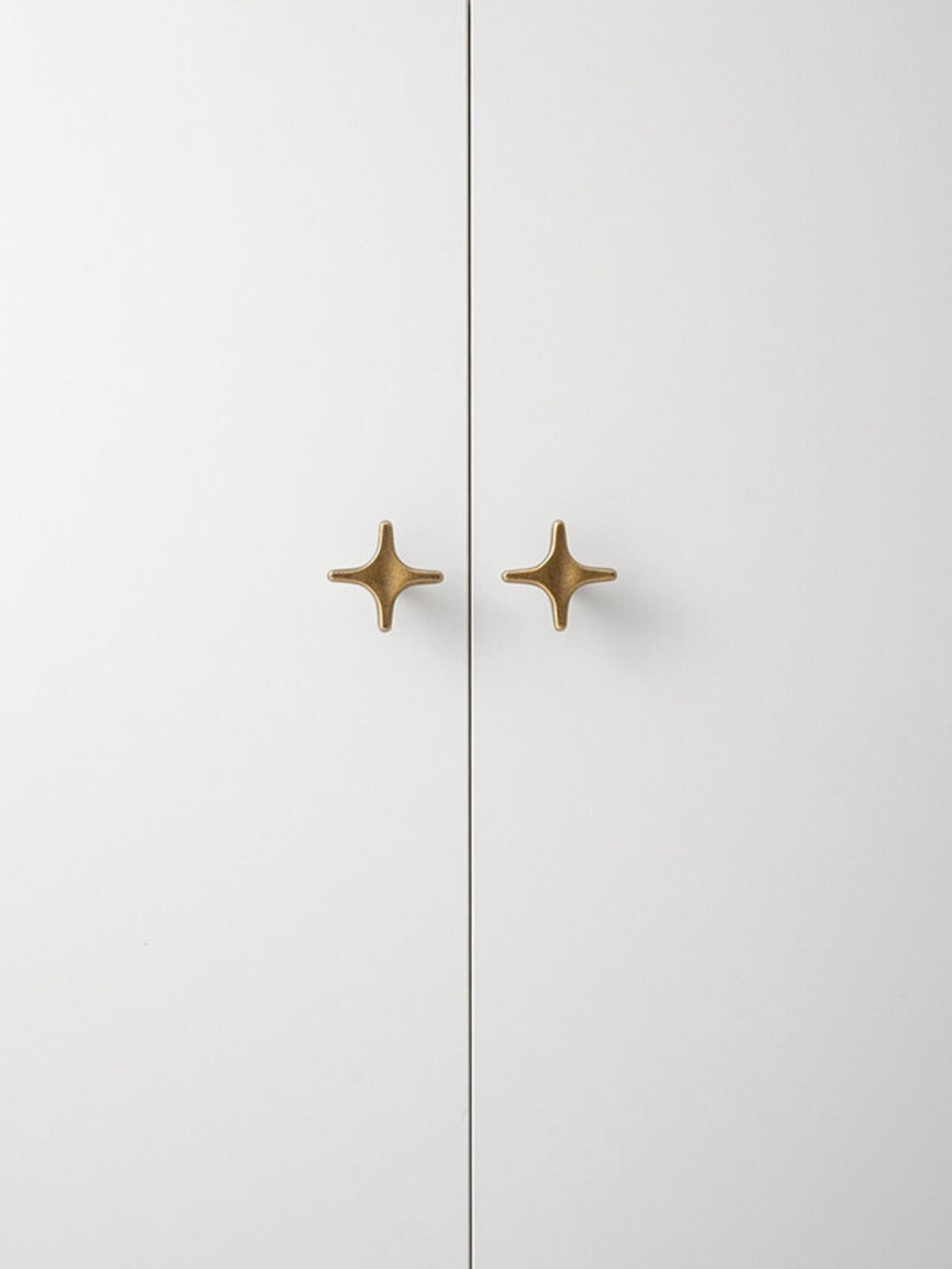 Antique Brass Star Cabinet Knob on White Cabinet Door OlumeHardware