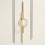 Close-up satin gold circle ring door pull on cream panelled wardrobe door