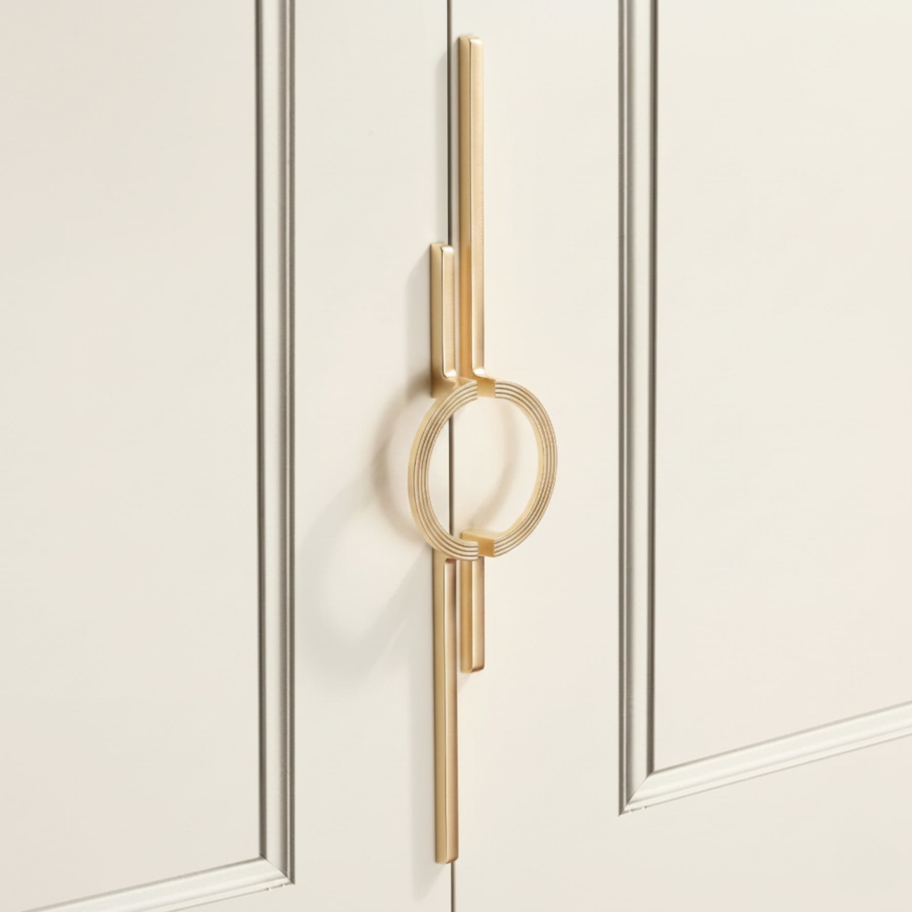 Close-up satin gold circle ring door pull on cream panelled wardrobe door