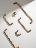 Set of brushed brass cabinet handles on a white background