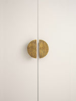 Antique brass sunray half-moon pulls on white cabinet doors